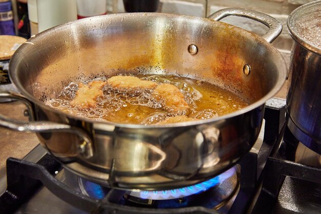 Beignets français Bugnes dans l'huile bouillante dans une casserole