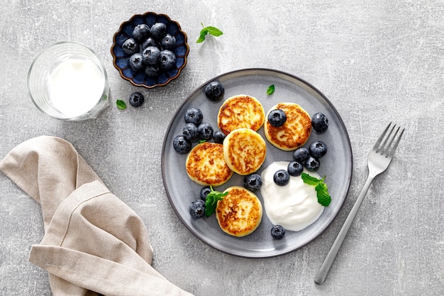 Beignets de fromage cottage avec bleuets frais et yaourt pour le petit-déjeuner copie espace vue d'en haut