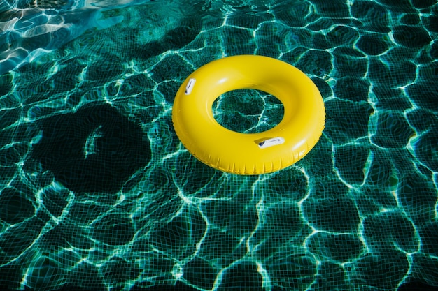 Photo des beignets gonflables jaunes flottant dans une piscine. le concept de l'heure d'été de personne.