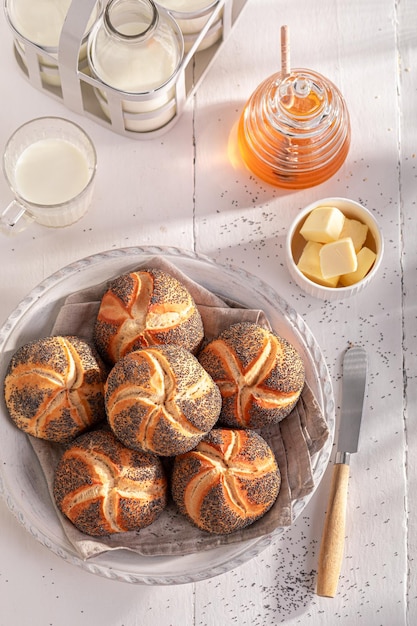 Photo des beignets kaiser délicieux avec des graines de pavot servis avec du lait