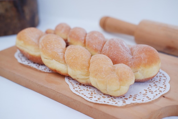 Beignets de pain sur la table en bois avec rouleau à pâtisserie en bois