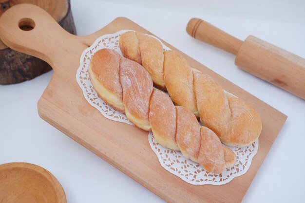 Beignets de pain sur la table en bois avec rouleau à pâtisserie en bois