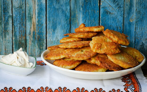 Beignets de pommes de terre dans un grand plat, crème sure