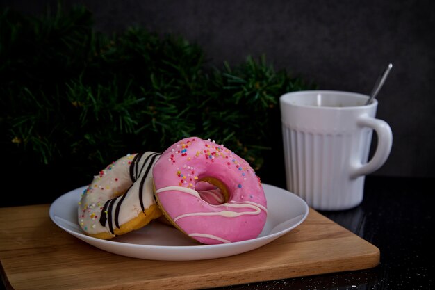 Beignets roses sur une assiette avec du café