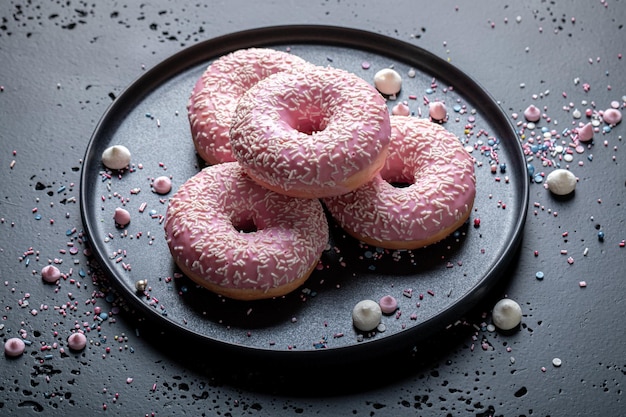 Des beignets roses savoureux et colorés comme collation populaire