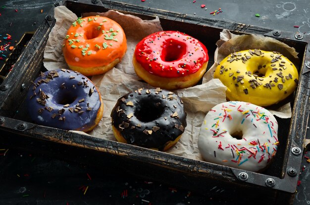 Beignets sucrés colorés dans une boîte en bois Vue de dessus Mise à plat