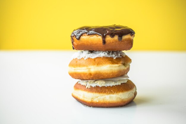 Des beignets sucrés de différentes couleurs vives se trouvent dans une grande pile sur un fond coloré