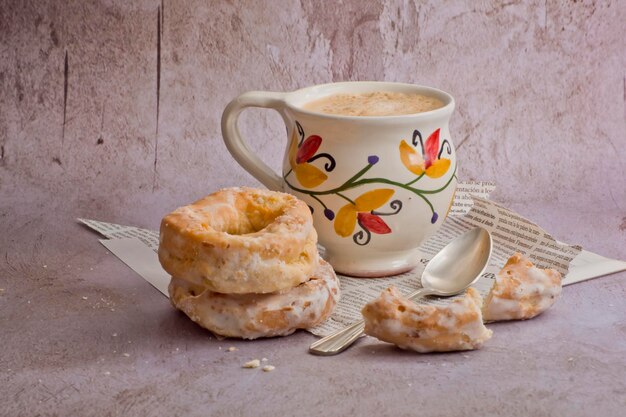 Beignets traditionnels à côté d'une tasse vintage avec du latte