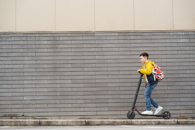 Bel adolescent sur un scooter électrique