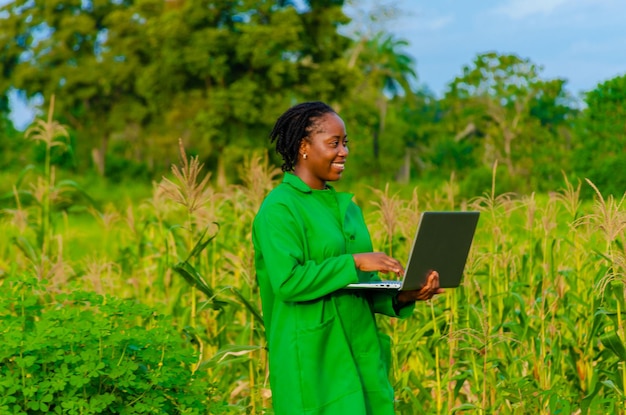 Bel agriculteur africain à la ferme à l'aide d'un ordinateur portable