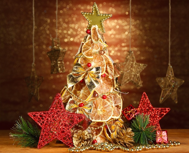 Bel arbre de noël de citrons secs avec décor, sur fond brillant