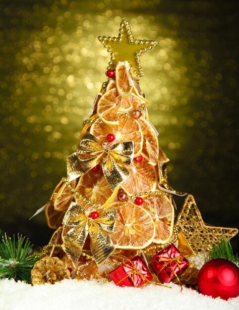 Bel arbre de noël de citrons secs avec décor, sur fond brillant