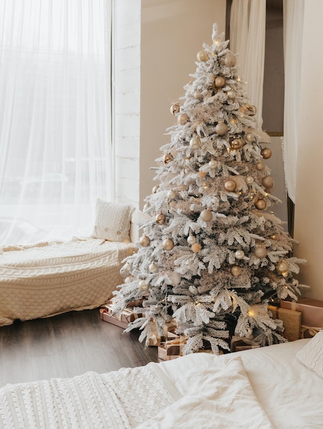Un bel arbre de Noël dans un salon décoré avec un lit Intérieur festifNoël