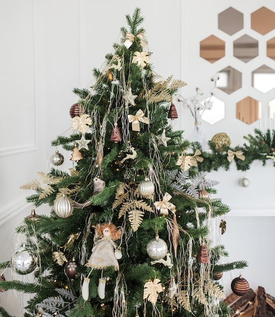 Bel arbre de Noël décoré de boules et de nombreux cadeaux différents