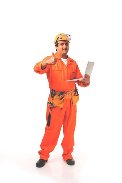 Bel électricien ou ingénieur asiatique indien en action avec un chapeau de sécurité jaune isolé