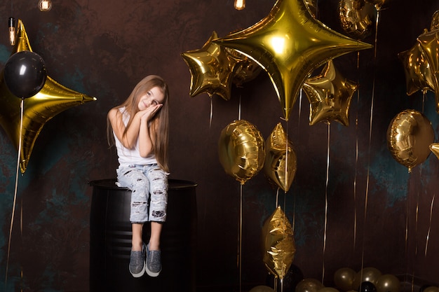 Bel enfant assis avec le ballon. joli visage. Une jolie petite fille