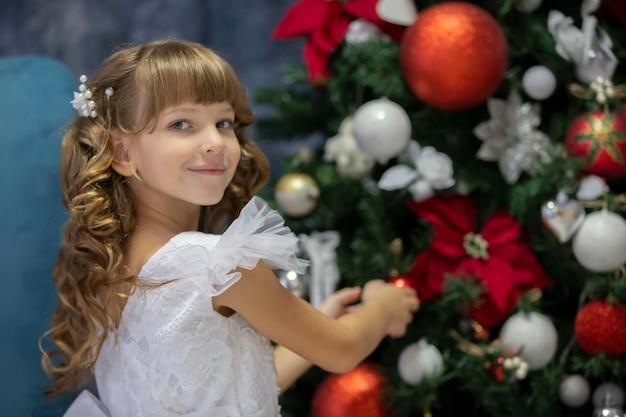 Un bel enfant décore un sapin de Noël Fille élégante à Noël