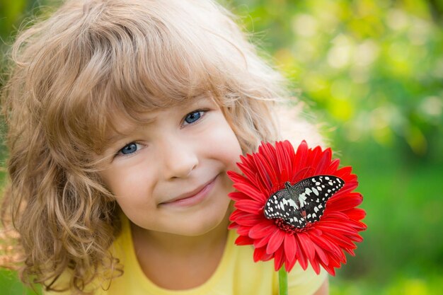 Bel enfant avec papillon dans le parc du printemps Heureux enfant jouant à l'extérieur