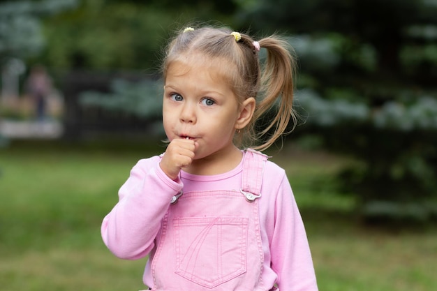 Bel enfant avec sucette dans le parc d'été