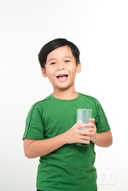 Bel enfant avec un verre de lait isolé sur blanc