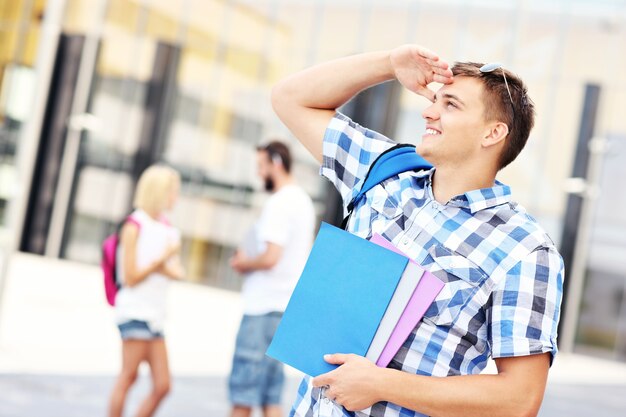 un bel étudiant regardant vers la gauche sur le campus