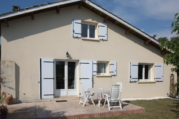 Bel extérieur de maison avec fenêtres bleues et jardin