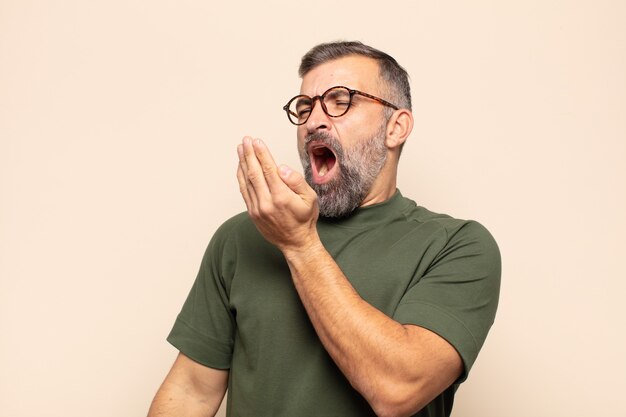 Bel homme adulte bâillant paresseusement tôt le matin, se réveillant et à la somnolence, fatiguée et ennuyée