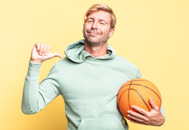 bel homme adulte blond avec un ballon de basket