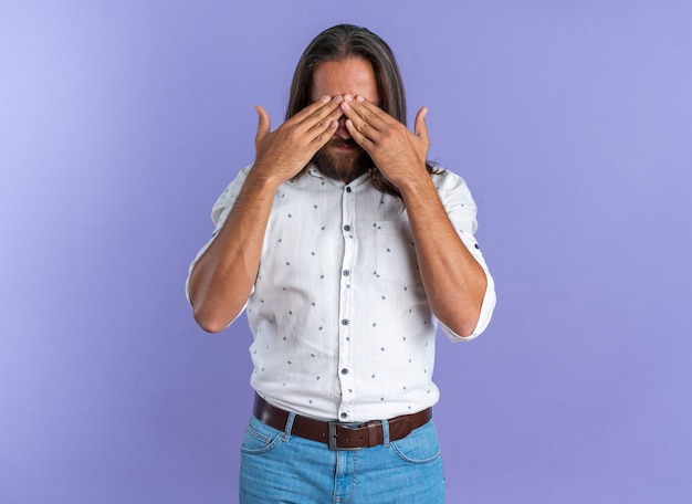 Bel homme adulte sérieux portant des lunettes couvrant les yeux avec les mains