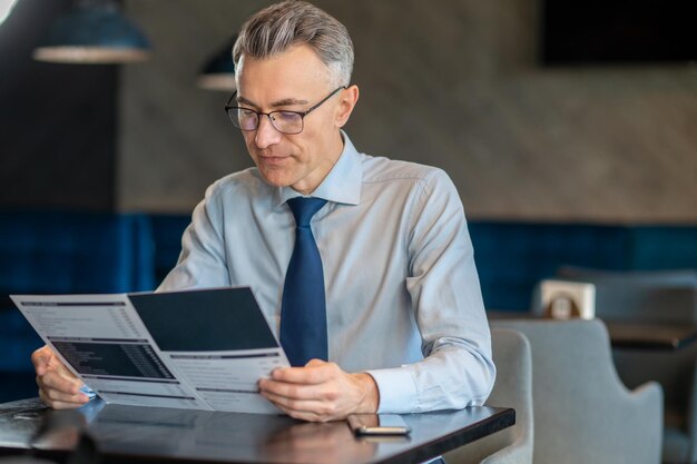 Bel homme d'affaires assis dans un café