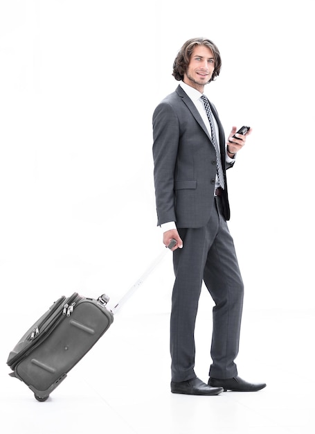 Bel homme d'affaires avec bagages en tapant des SMS sur le smartphone