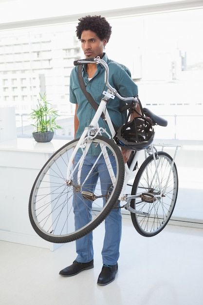 Bel homme d&#39;affaires debout avec son vélo