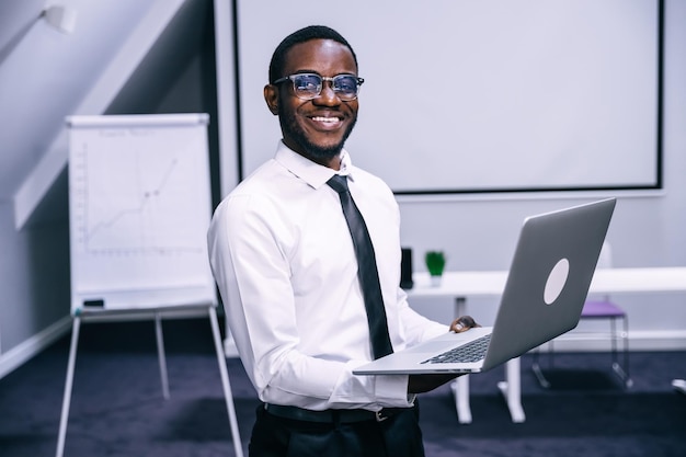 Bel homme d'affaires exécutif afro-américain joyeux dans l'espace de travail de bureau