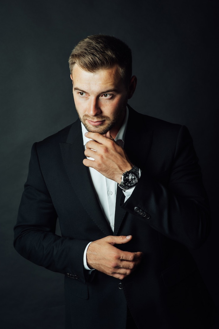 Photo bel homme d'affaires masculin avec costume posant dans un studio photo.