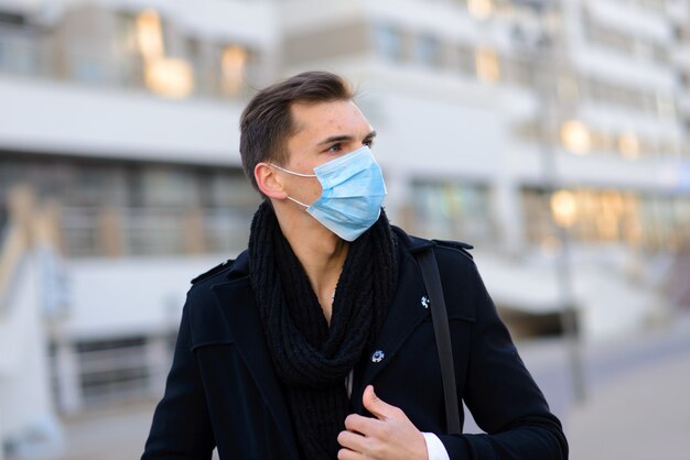 Bel homme d'affaires avec un masque facial à l'extérieur