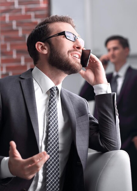 Bel homme d'affaires parlant sur téléphone portable au bureau