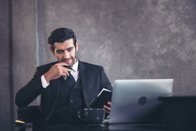 Bel homme d'affaires planifie le travail et prend des notes.