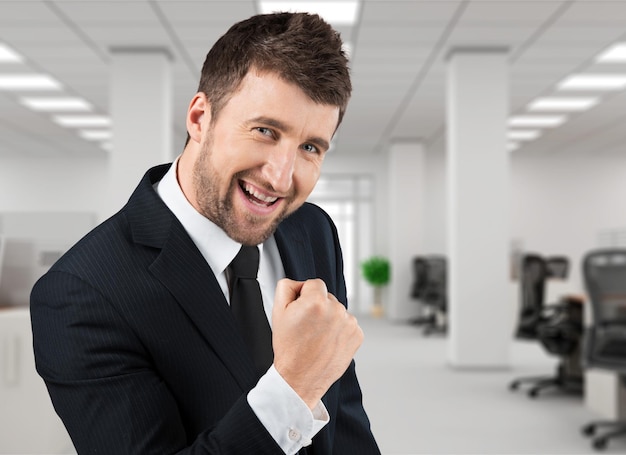 Bel homme d'affaires prospère portant un costume avec des expressions faciales