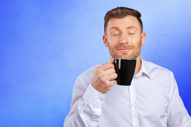 Bel homme d'affaires souriant tenant une tasse