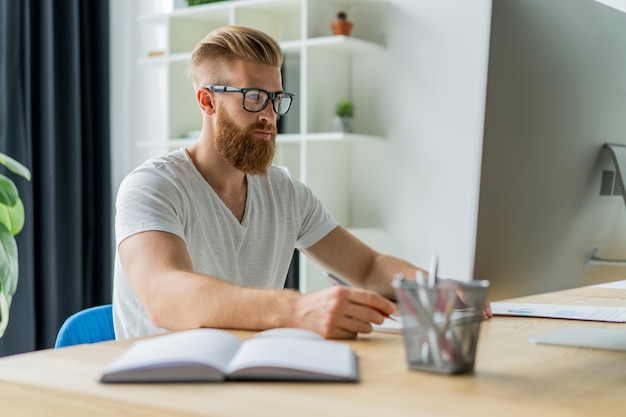 Bel homme d'affaires travaillant sur un ordinateur dans un bureau.