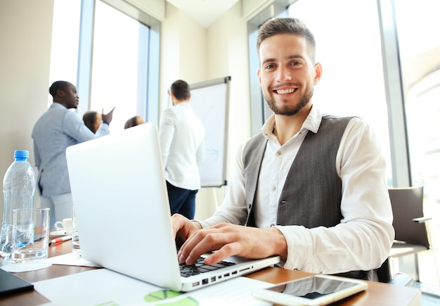 Bel homme d'affaires travaillant avec un ordinateur portable au bureau.