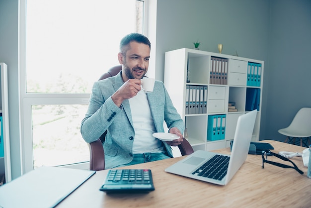 Bel homme d'affaires avec une veste bleue travaillant au bureau