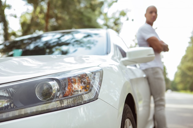 Bel homme africain, appréciant voyager en voiture sur un roadtrip