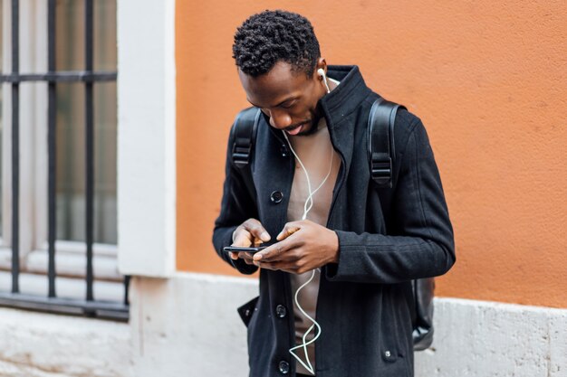 Bel homme afro-américain à l'aide de téléphone portable.