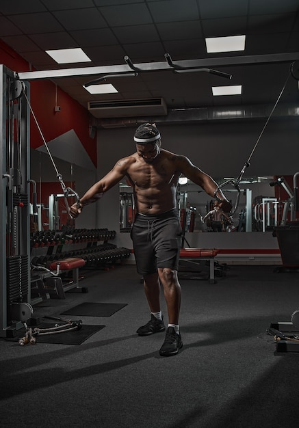 Bel homme afro-américain athlétique musclé exerçant les muscles de la poitrine de formation dans la salle de gym