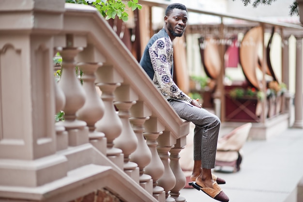 Bel homme afro-américain portant des vêtements traditionnels dans la ville moderne.