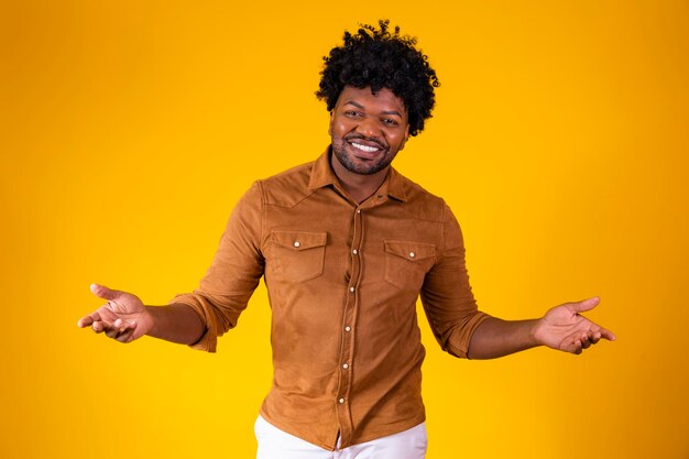 Bel homme afro souriant à la caméra pointant vers l'espace de copie