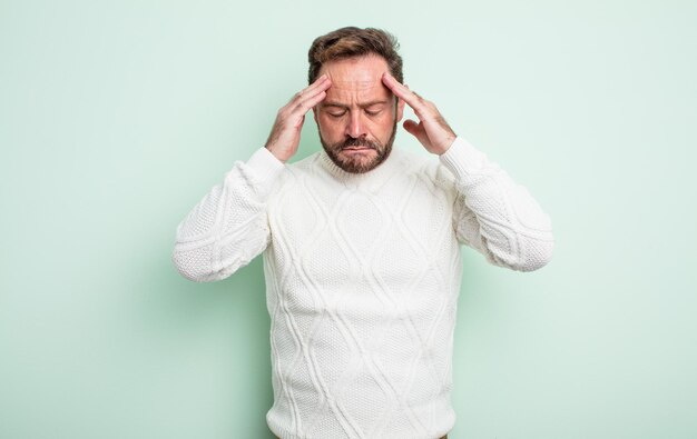 Bel homme d'âge moyen à l'air concentré, réfléchi et inspiré, remue-méninges et imaginant avec les mains sur le front