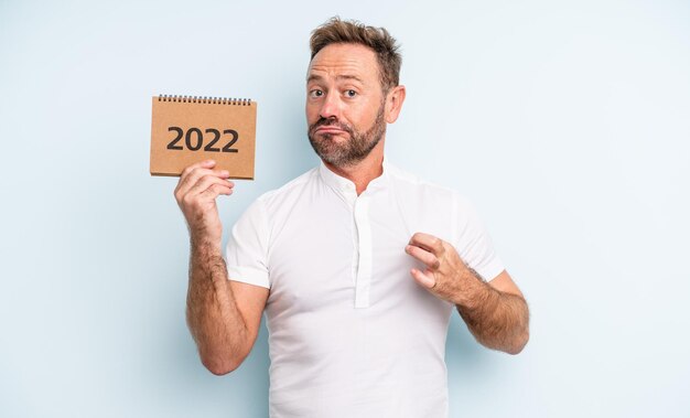 Bel homme d'âge moyen à la recherche d'un concept de calendrier 2022 positif et fier avec succès