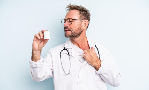 Bel homme d'âge moyen se sentant stressé, anxieux, fatigué et frustré. médecin avec bouteille de pilules